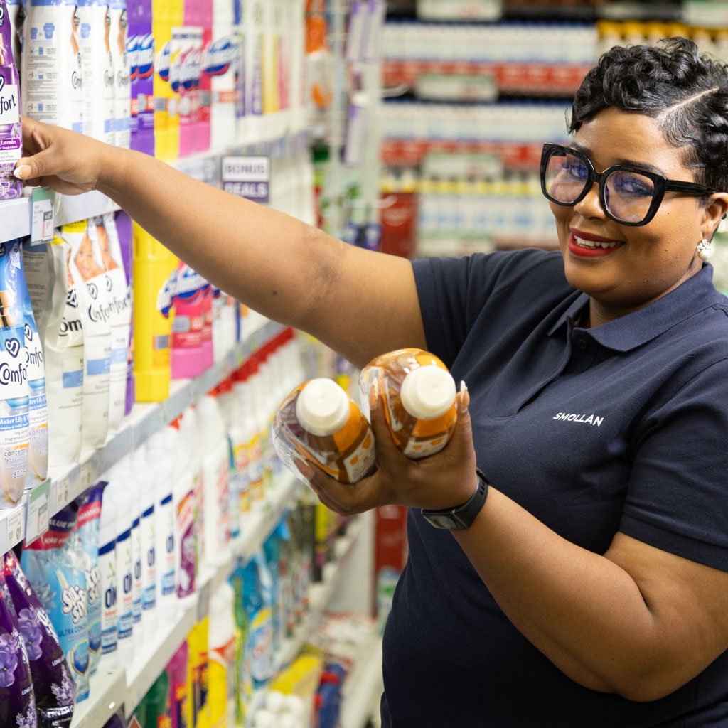 Smollan retail merchandiser stocking products on supermarket shelf in South Africa, demonstrating in-store execution and FMCG retail support