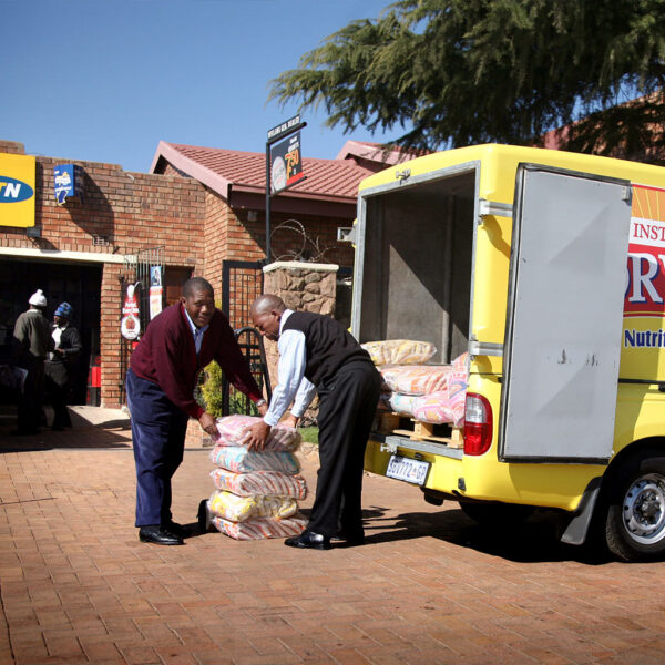 Field sales team unloading products from a van for delivery to a retail store