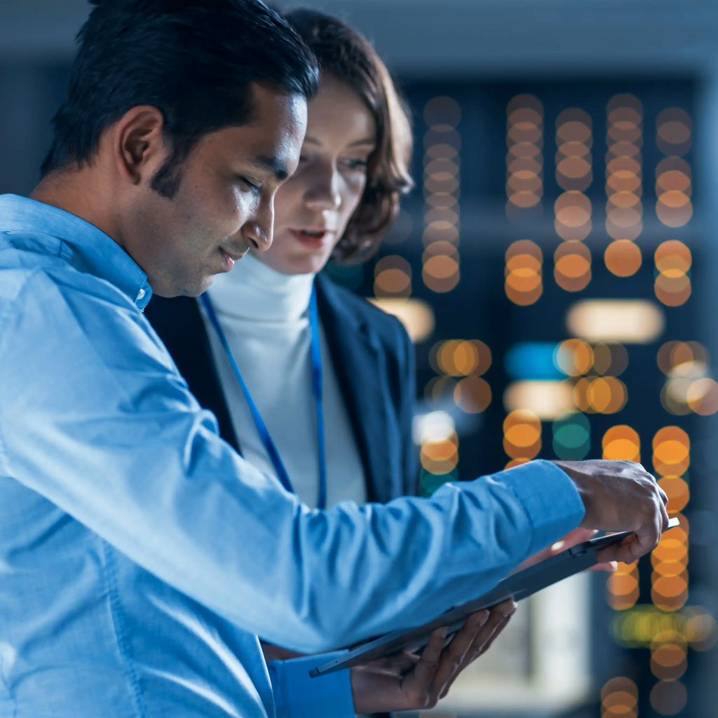 Professionals reviewing data on a tablet in a cloud and analytics environment