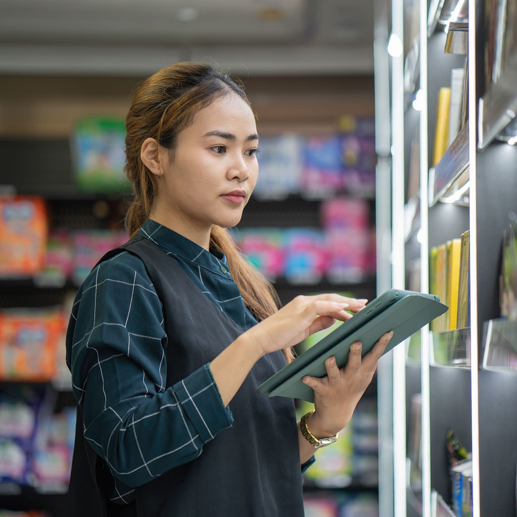 Retail worker using a tablet in-store to capture data and monitor product information