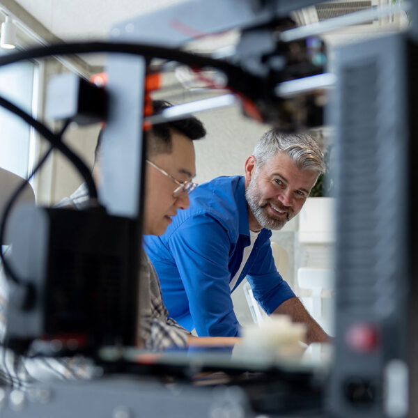 Professionals collaborating around technology equipment to analyse digital commerce data