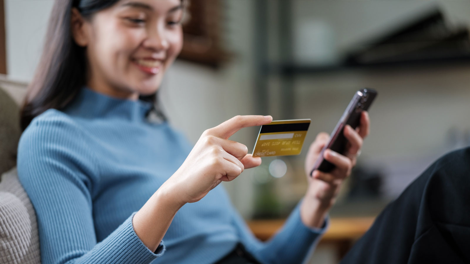Shopper making an online purchase on a smartphone using a credit card