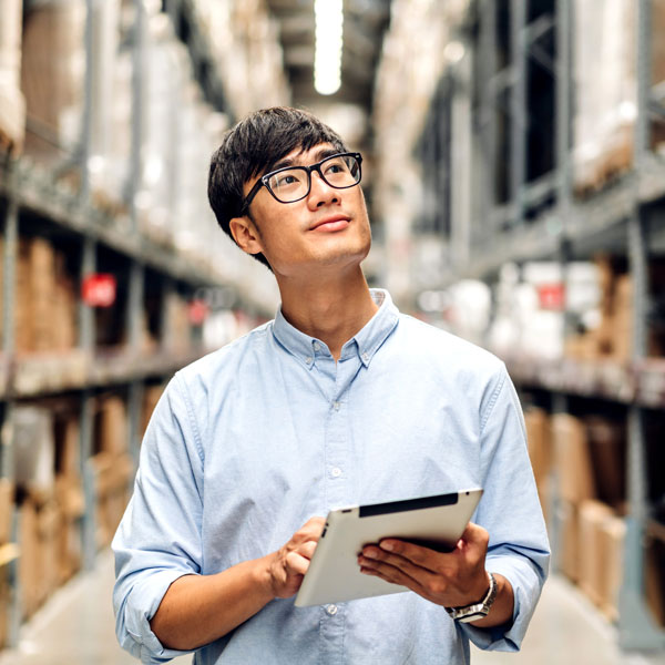 Warehouse professional using a tablet to manage inventory in a distribution facility