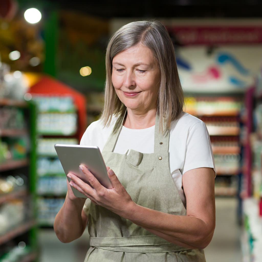 Retail merchandiser using a tablet in a supermarket to manage promotions and stock