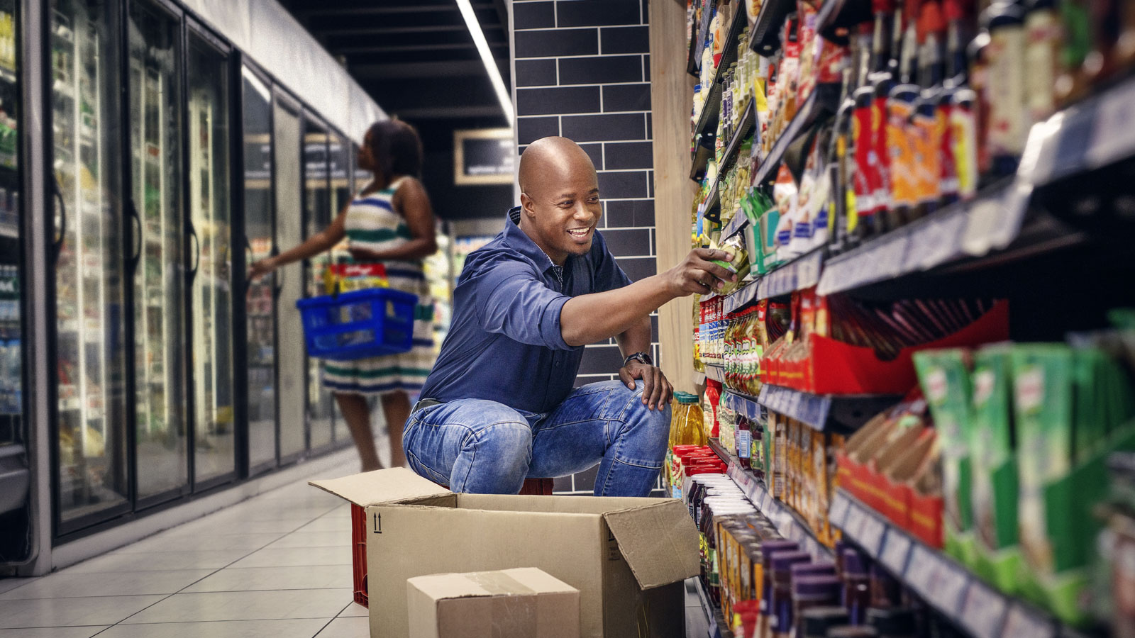 Retail merchandiser stocking products on a supermarket shelf