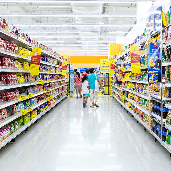 Shoppers walking through a large supermarket aisle in a modern retail environment