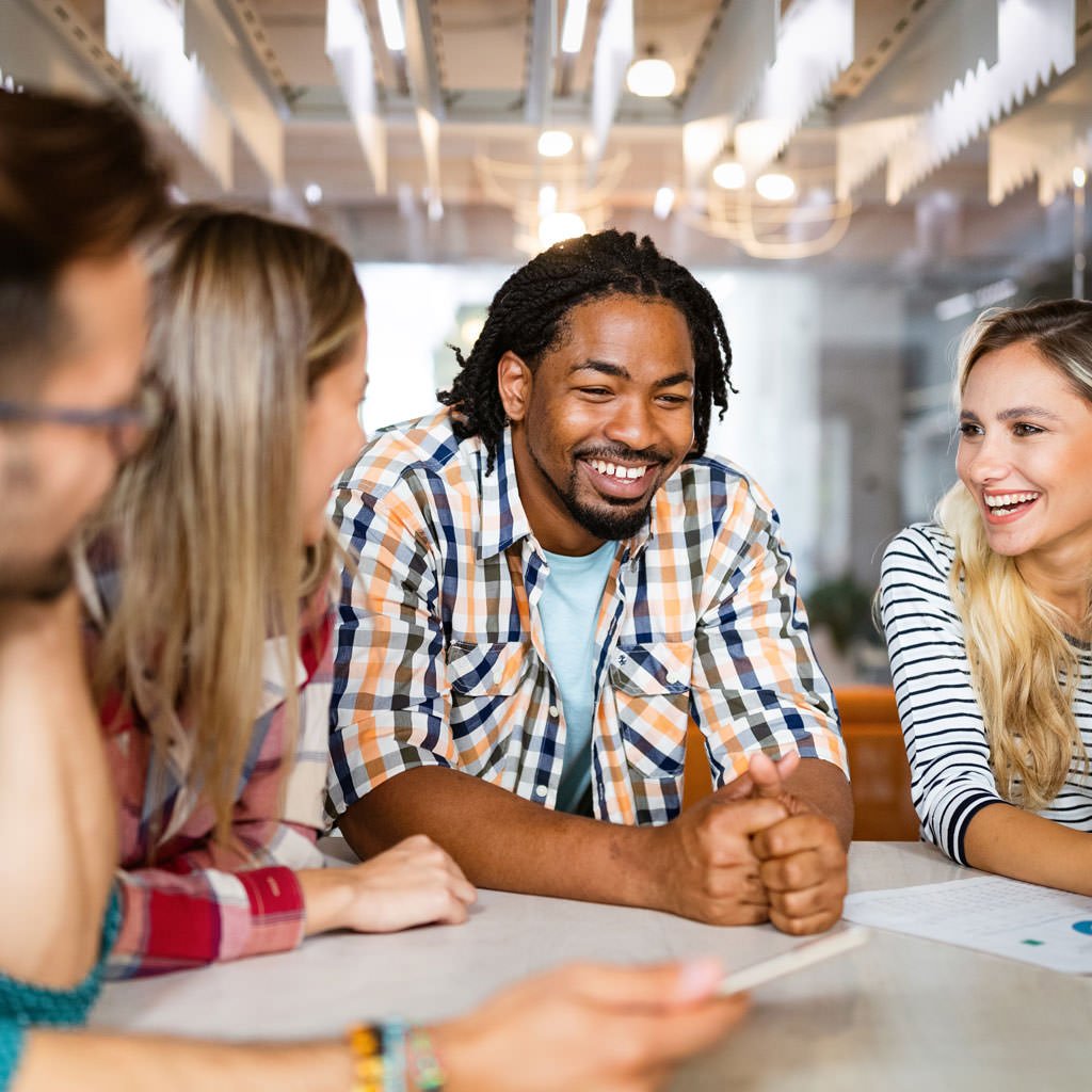 Team members collaborating and smiling during a meeting in a modern office
