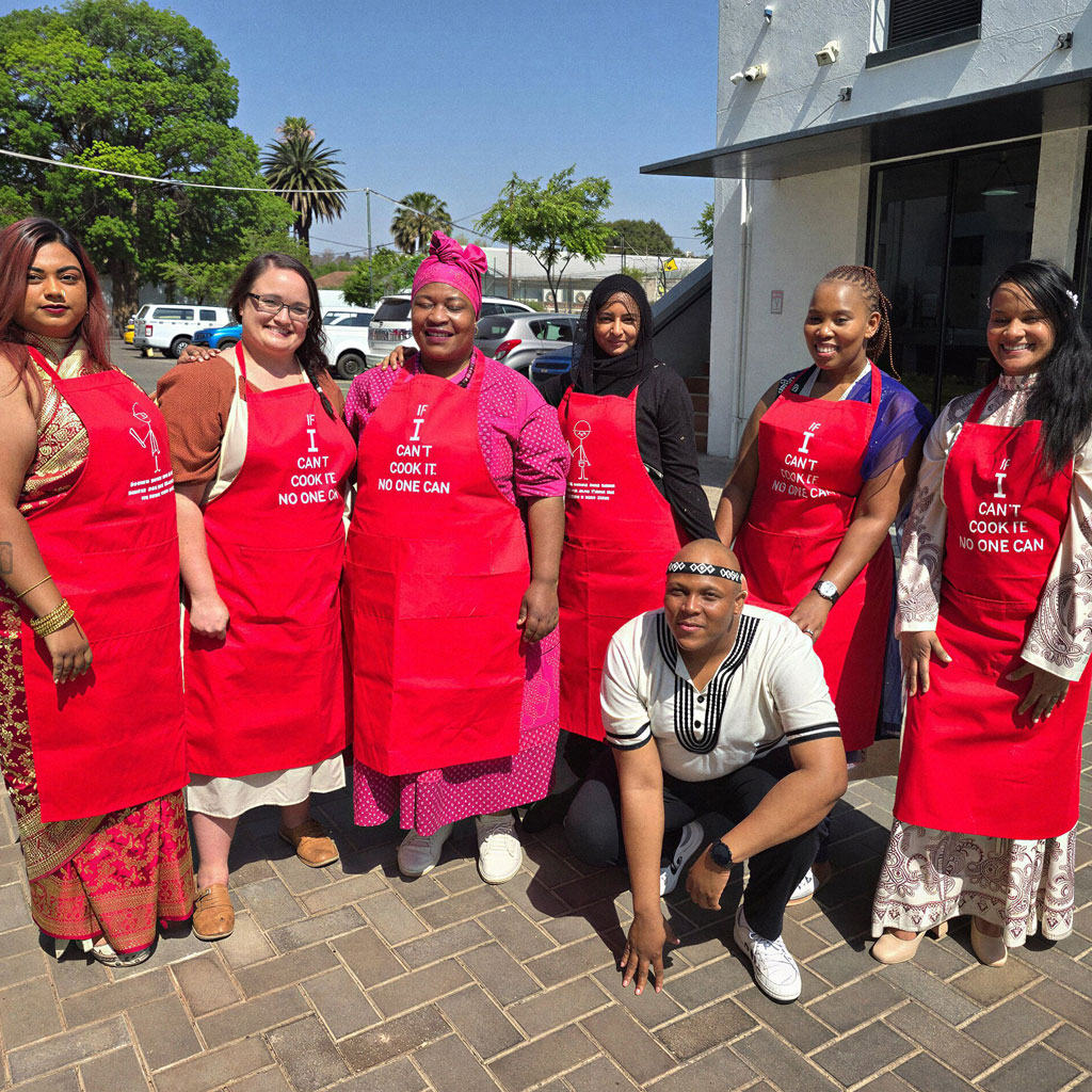 Smollan team members wearing red aprons during a community outreach and skills development initiative.